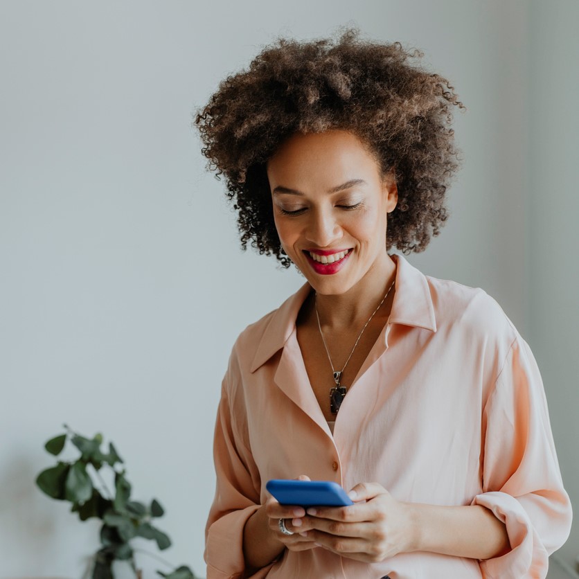 Retail Website Lifestyle Content A young woman using her mobile phone for texting at work.